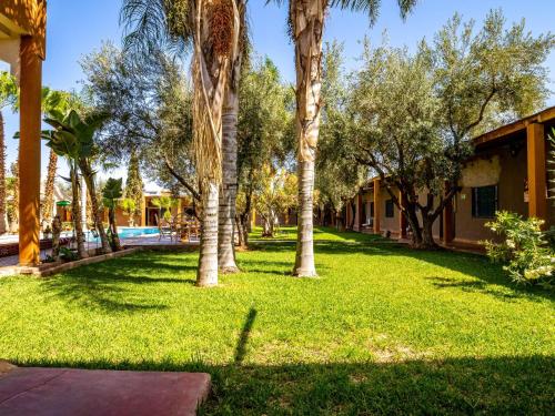 a park with palm trees and a swimming pool at Kasbah Alili in Marrakech