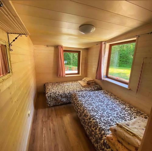 a small room with two beds in a tiny house at Vila "Santa Barbara" in Toliejai