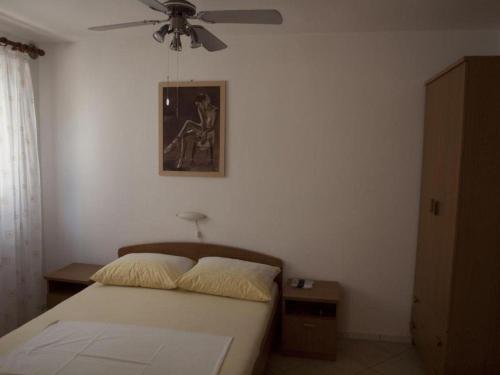een slaapkamer met een bed en een plafondventilator bij Ferienwohnung für 2 Personen ca 28 qm in Vir, Dalmatien Inseln vor Zadar in Vir