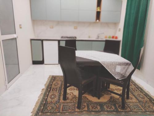 a table and chairs in a room with a kitchen at Dar Ranim Tozeur in Tozeur