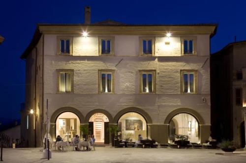 duży budynek z ludźmi siedzącymi przed nim w obiekcie Palazzo Bontadosi Hotel & Spa w mieście Montefalco