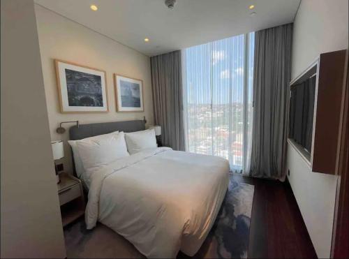 una camera d'albergo con un letto e una grande finestra di Emaar Square Rezidans a Istanbul