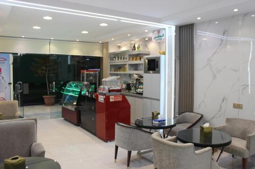 a restaurant with two tables and chairs and a counter at Bahget Eljouf Furnished Apartment in Sakakah