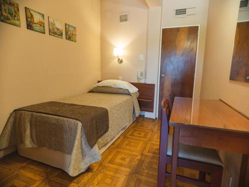 Habitación pequeña con cama y escritorio. en Alquilo habitación en Buenos Aires