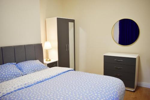 a bedroom with a bed and a dresser and a mirror at Pleasant Room nearby edgbaston stadium in Birmingham