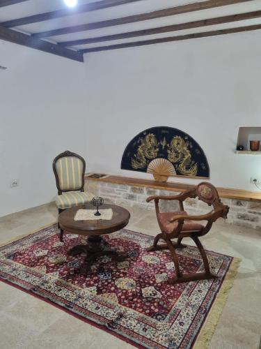 a living room with a chair and a table at Villa Olive Old Qeparo in Qeparo