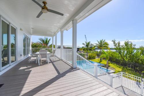 a white house with a porch with a ceiling fan at Mastway House -Pool & Dock! in Key West