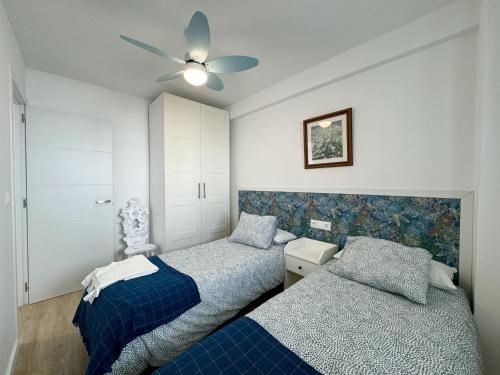 1 Schlafzimmer mit 2 Betten und einem Deckenventilator in der Unterkunft Apartamento Nuevo Centro Nerja in Nerja