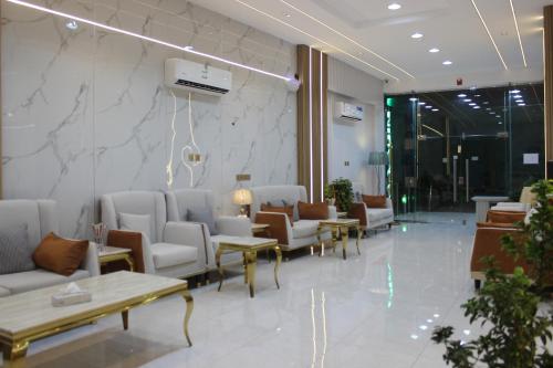 a lobby with a waiting room with couches and tables at Bahget Eljouf Furnished Apartment in Sakakah