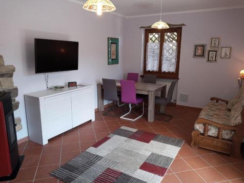 een woonkamer met een tafel en een televisie bij Ferienwohnung für 2 Personen 3 Kinder ca 75 qm in Val Maria-pur, Trentino Ledrosee in Mezzolago