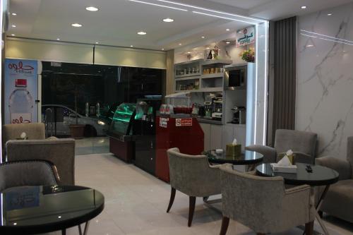 a restaurant with two tables and chairs and a counter at Bahget Eljouf Furnished Apartment in Sakakah