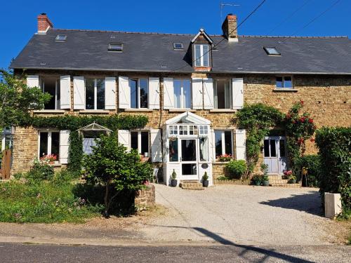 a brick house with white doors and windows at La Paix, Chambre d'Hôte en Suisse Normande in Condé-sur-Noireau