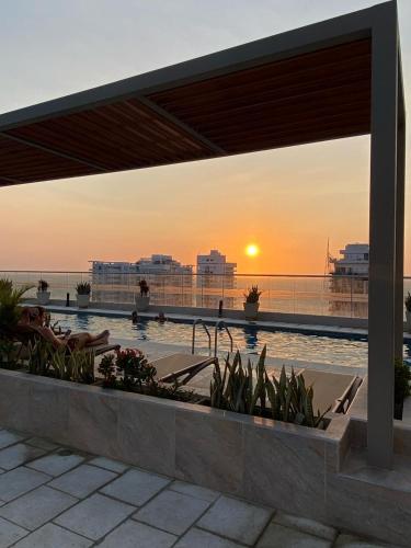 a view of a pool with the sunset in the background at El Samario Cumbia Host-Playa Salguero- Santa Marta in Gaira