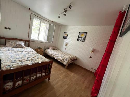 une chambre avec deux lits et une fenêtre dans l'établissement Maison quartier parc de Tremblay, à Champigny-sur-Marne