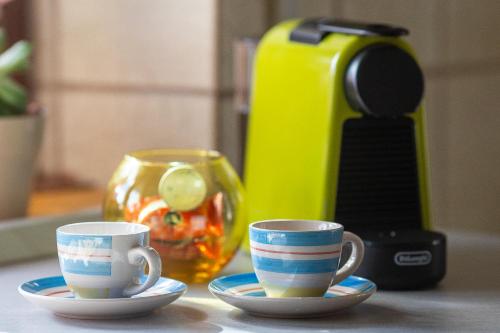 Corno Grande - spacious apartment - 2 baths - Wi Fi- city center - free parking في لاكويلا: كوبين جالسين على الأطباق على منضدة