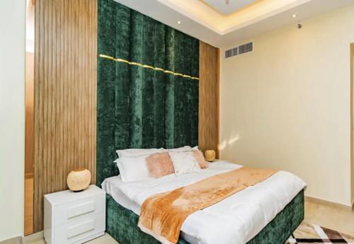 - une chambre avec un grand lit et un mur vert dans l'établissement Living in a Tower in Downtown - Extravagance at a Budget Price - Only 5 Minutes’ Walk to Dubai Mall, à Dubaï