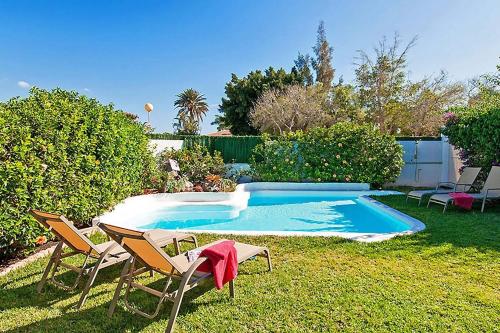 einen Pool mit zwei Gartenstühlen und einem Tisch in der Unterkunft Ferienhaus mit Privatpool für 4 Personen ca 125 m in Maspalomas, Gran Canaria Südküste Gran Canaria in Maspalomas