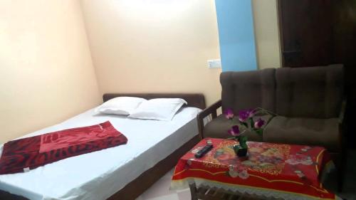 a room with a bed and a chair with a table at Hotel Asia in Cox's Bazar