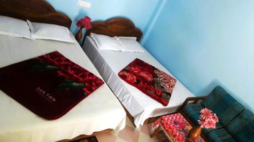 two beds in a room with red and green pillows at Hotel Asia in Cox's Bazar