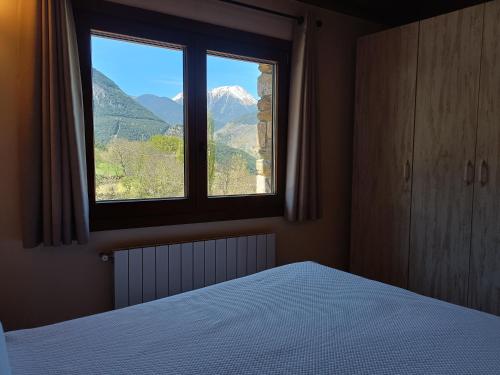 1 dormitorio con cama y ventana con vistas en Rural Berrós en Guingueta