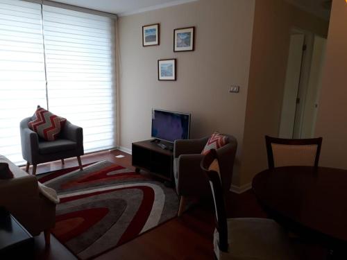 sala de estar con TV y 2 sillas en Los Quillayes, en Los Ángeles