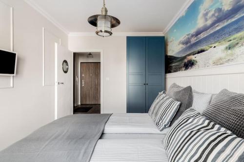 una camera da letto con un grande letto con cuscini a righe di Gdańsk Apartment with Sunny Balcony a Danzica