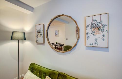 a mirror on a wall with a green couch at Elegant 1 Bedroom Flat in Brentwood