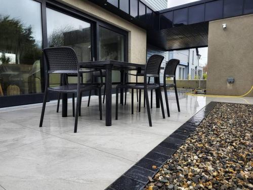 a black table and chairs in front of a building at Sea Breeze in Wexford