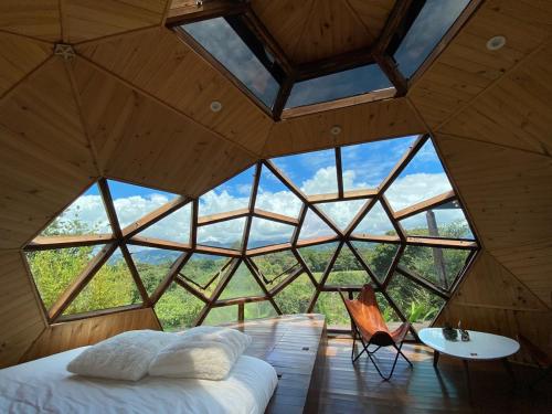 a bed in a room with a large window at Nacimiento Glamping in San Agustín