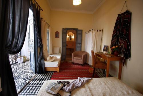 a room with a bedroom with a bed and a desk at Dar Touyir in Marrakech