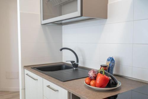 a kitchen with a sink and a bowl of vegetables at Ferienwohnung für 2 Personen ca 35 qm in Alghero, Sardinien Sassarese in Alghero