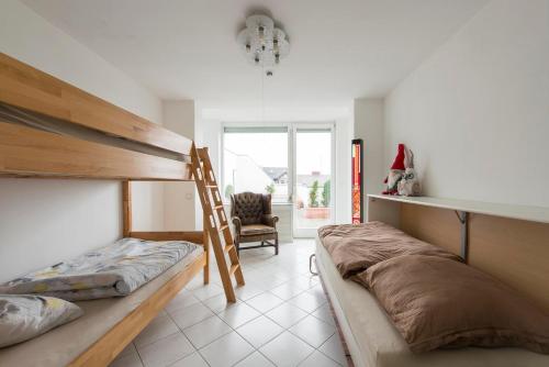 a bedroom with two bunk beds and a chair at Munich Rooftop Retreat in Munich