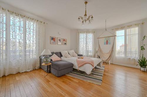- une chambre avec un lit, un canapé et des fenêtres dans l'établissement Appartement spacieux avec hamac + parking gratuit, à Gentilly