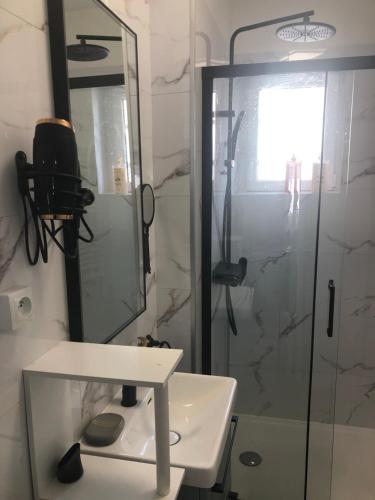La salle de bains est pourvue d'une douche et d'un lavabo blanc. dans l'établissement Appartement Chaleureux -Paris-CDG-RER B-Parc des Expos de Villepinte-Disneyland-Asterix-Stade de France-, à Vaujours