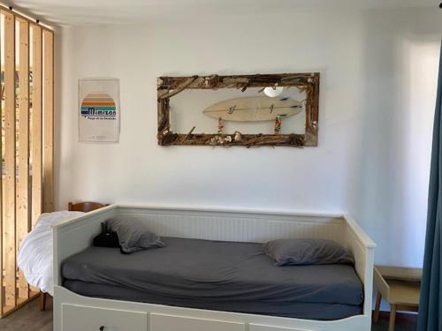 une chambre avec un lit avec un miroir au mur dans l'établissement Studio avec jardinet Mimizan plage, à Mimizan