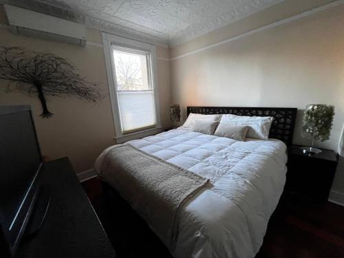 1 dormitorio con 1 cama blanca grande y ventana en GEM of a Free-Standing Family House in Great Neighborhood en Brooklyn