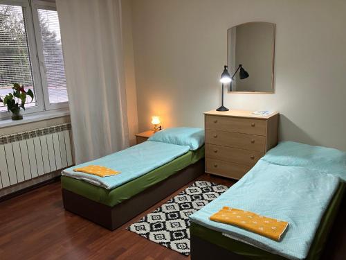 two twin beds in a room with a dresser at Kosice in Košice