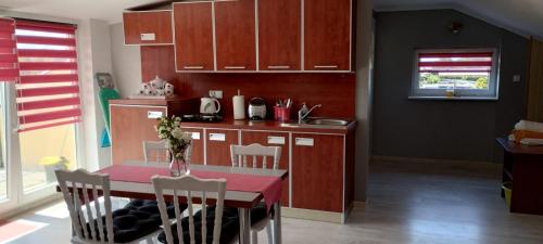 kuchnia ze stołem i krzesłami oraz kuchnia z brązowymi szafkami w obiekcie Dom na Błękitnej w Karwieńskim Błocie