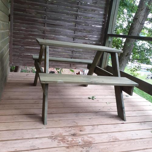 a wooden bench sitting on a wooden deck at domek na skarpie in Ruciane-Nida