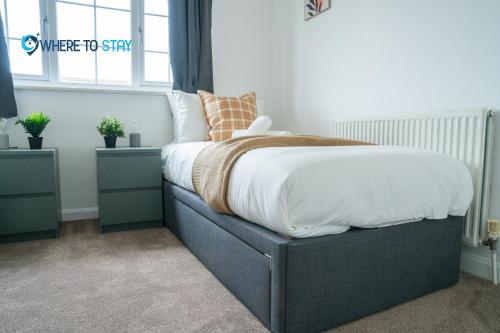 a bedroom with a black bed with white sheets and pillows at Elegant 3 bed apartment Luton in Luton