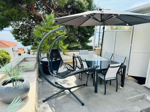 a table and chairs with an umbrella on a patio at Villa Sirenis in Trogir