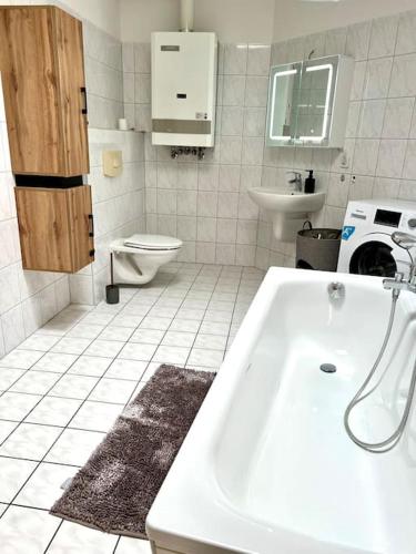 bagno bianco con lavandino e servizi igienici di Moderne Wohnung bei BASF a Hörlitz