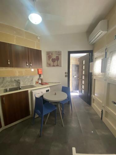 - une cuisine avec une table, des chaises et un évier dans l'établissement Birgu Studio Maisonette, à Il-Birgu