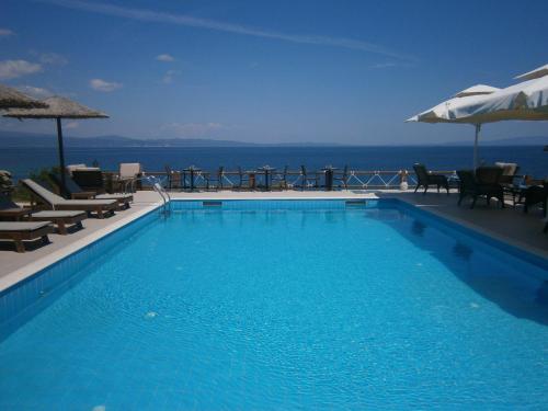 a swimming pool with a view of the ocean at Barbagiannis House in Ormos Panagias