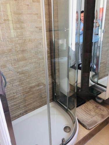 une douche avec une porte vitrée dans une salle de bain dans l'établissement Sea View Apartment 5 min from Monaco, à Roquebrune-Cap-Martin