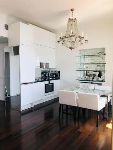 Il comprend une cuisine avec une table à manger et un lustre. dans l'établissement Sea View Apartment 5 min from Monaco, à Roquebrune-Cap-Martin