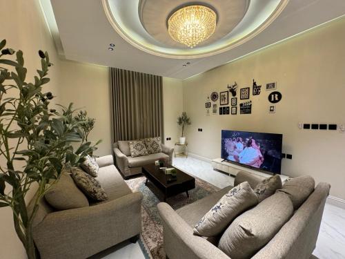 a living room with two couches and a tv at شقة فاخرة غرفة وصالة بالعارض دخول ذاتي ١٠ in Riyadh