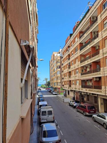 a city street with parked cars and buildings at Gabriella Apartment Near the beach in Puerto de Sagunto