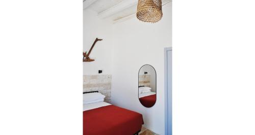 a bedroom with a red bed and a mirror at Casale Petrarolo in Monopoli