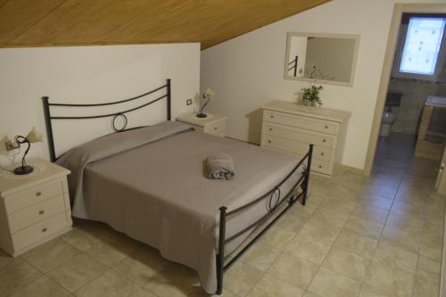 a bedroom with a bed and two dressers and a mirror at Casa Genisi in Scicli